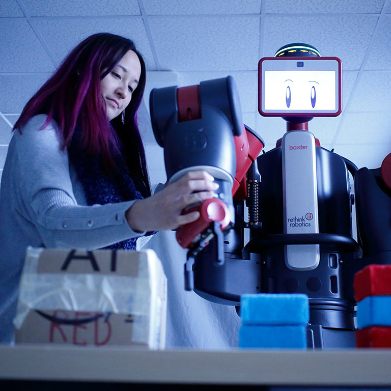 An student works with a robot for her research.